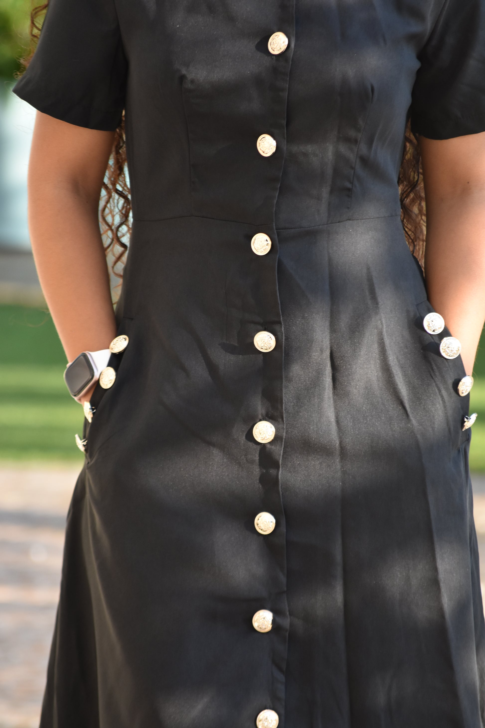 Vestido largo negro con botones dorados y bolsillo