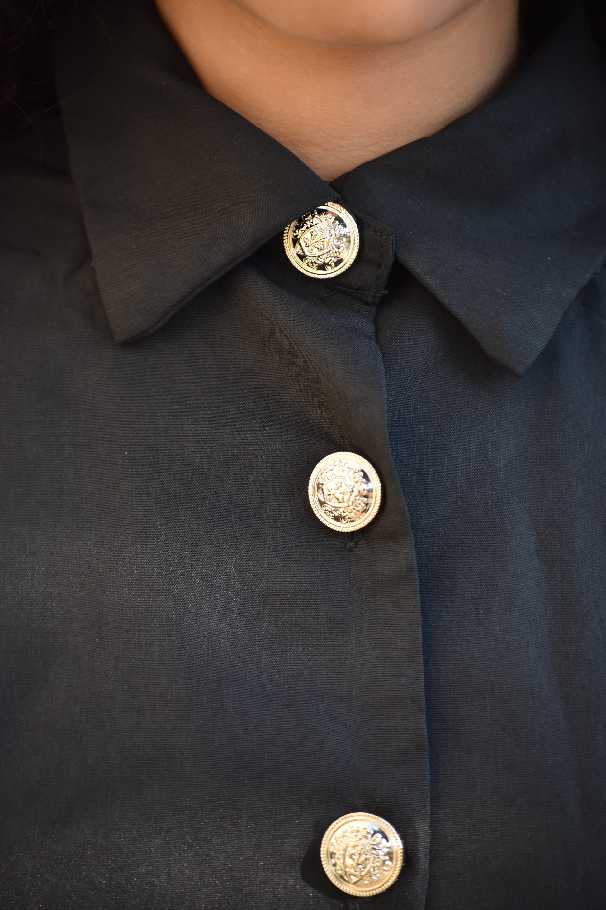 Vestido largo negro con botones dorados y bolsillo