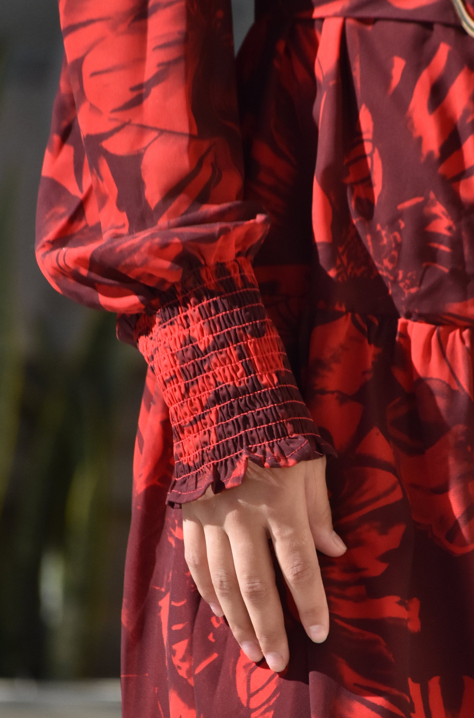 Vestido rojo con estampado de hojas y hebilla dorada