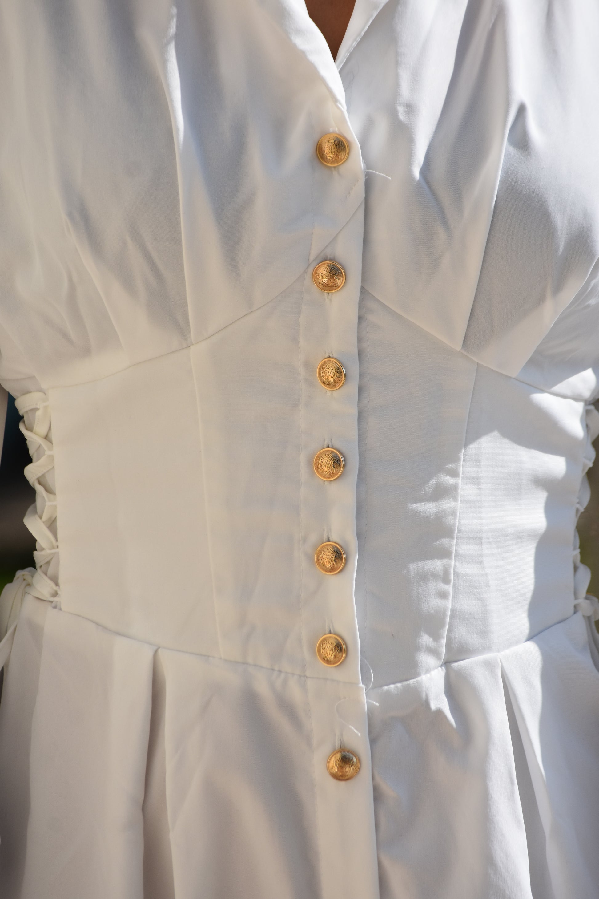 Vestido blanco con corsé a los lados y botones